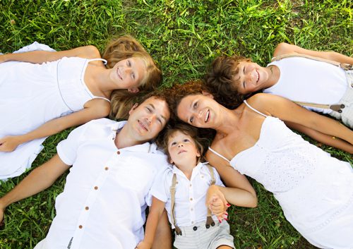 Family lying down in the grass.